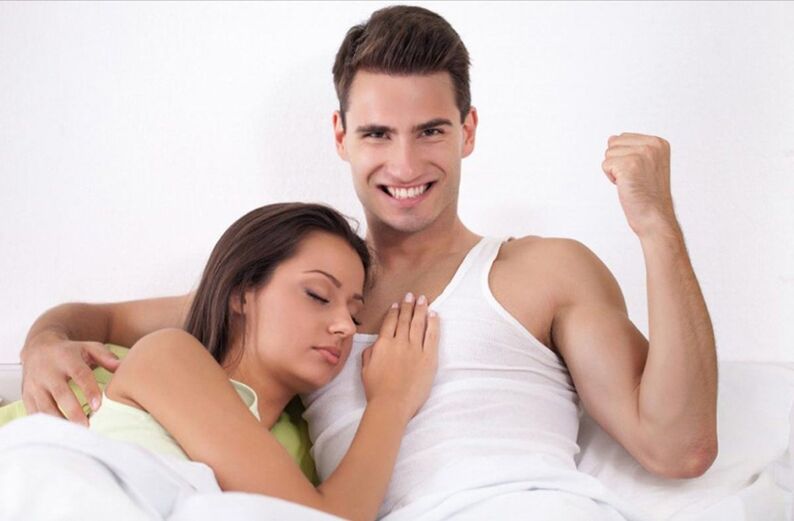 A strong man in bed with a girl